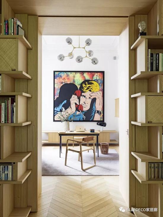 书桌是Jean Prouvé的设计。Oria扶手椅与字纸篓都出自爱马仕之家。吊灯由Lindsey Adelman设计。墙上的画作名为《310》，是Stepan Krasnov的作品。从玄关望向书房，两侧为定制书架，由橡木与藤编组合而成。公寓里无处不在的艺术作品，给安静克制的空间带来一抹奇幻色彩。