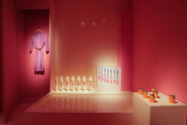 22.在粉色调营造的粉饰间中，五个各具特色的舞台场景围绕着以配饰和丝巾为主题的游戏桌。