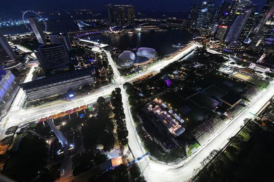 2016 年 9 月 15 日，在新加坡史丹福瑞士酒店（Swissotel The Stamford）上拍摄的一幅俯瞰图，即将开幕的新加坡 F1 大奖赛赛道上亮起了灯。（图片版权：ROSLAN RAHMAN/视觉中国）