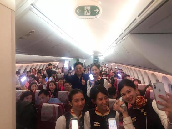 由海口至北京的HU7781上，乘客和空姐开启手机合影。（图片来源：海航官方公众号）