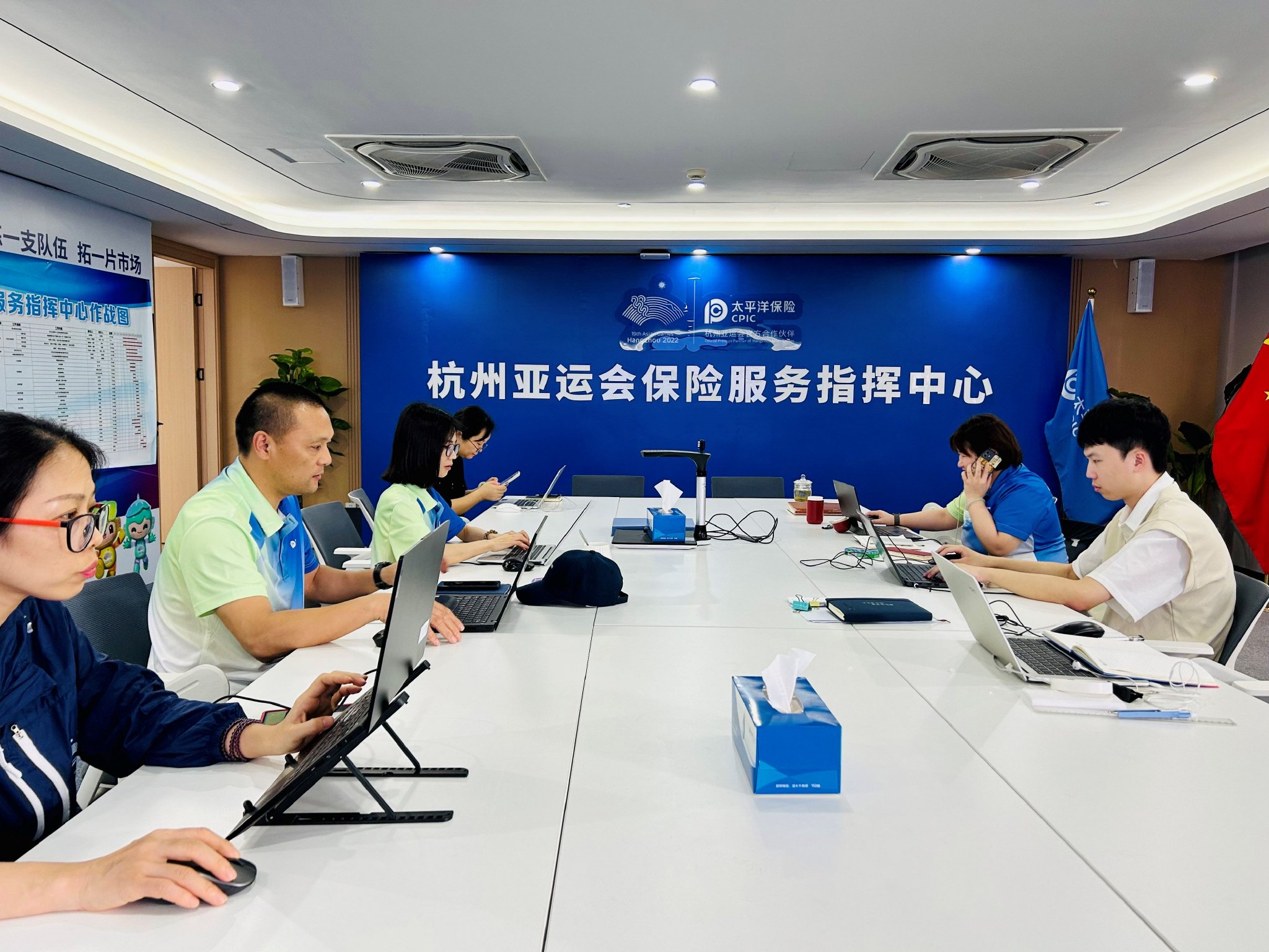 双节期间,丁国钢(左二)和同事们忙碌在保险指挥中心