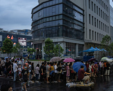 广州防控升级 市民雨中排队等候核酸检测