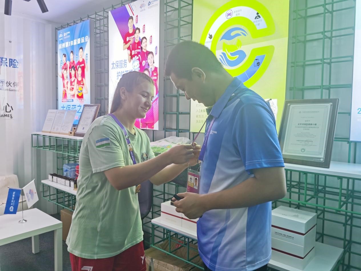 亚运村探店运动员与蔡亦军交换徽章并为他的服务点赞