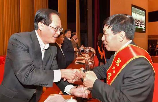 浙江省委书记车俊向圣奥集团有限公司董事长倪良正颁发奖杯。