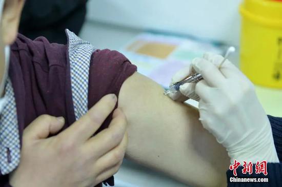 1月8日，北京市西城第一文化馆，新街口社区卫生服务中心医护人员为接种者注射疫苗。中新社记者 田雨昊 摄