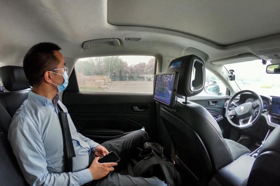 4月25日，在北京经济技术开发区，一名乘客在体验“主驾无人、副驾驶配备安全员”的无人驾驶车。新华社记者 彭子洋 摄