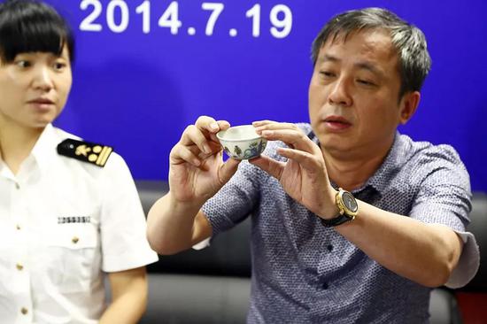  2014年07月19日，上海，刘益谦手拿鸡缸杯向媒体展示：这么多记者，我手心都出汗了。来源：视觉中国