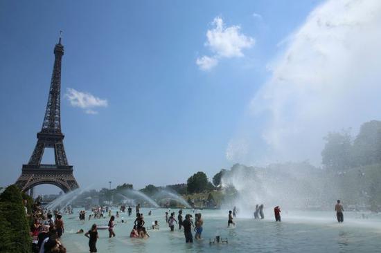 2019年6月26日，在法国巴黎的热浪中，人们在特罗卡德罗花园的喷泉旁避暑。