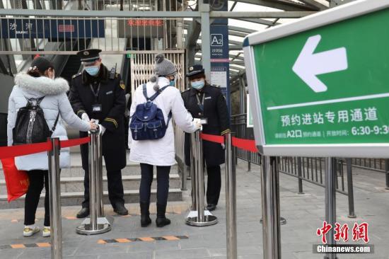  3月6日，北京地铁昌平线沙河站，乘客在站务员指导下扫码通过预约通道乘车。中新社记者 蒋启明 摄