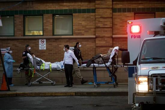 3月28日，医护人员将病人送往美国纽约布鲁克林一家医院的急诊室。摄影/郭克