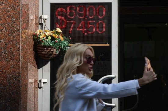 2020年3月9日，俄罗斯首都莫斯科，一名女子在外汇兑换点的汇率显示屏旁自拍。新华社发（叶甫盖尼·西尼岑摄）