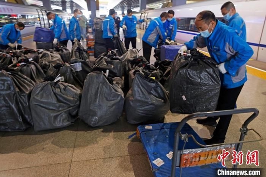 工作人员将快递物品从抵达上海的列车车厢内搬出。殷立勤 摄