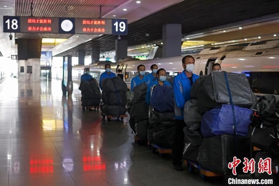 工作人员将快递物品从抵达上海的列车车厢内搬出。殷立勤 摄
