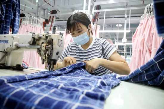 2021年7月11日,浙江桐庐,工人在制作浴袍和睡衣。 图/视觉中国