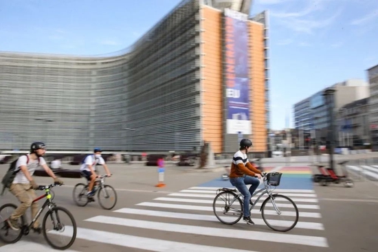 2020年9月20日，人们骑行经过位于比利时布鲁塞尔的欧盟委员会总部大楼。新华社记者张铖摄
