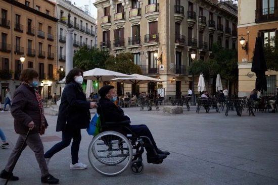 2021年10月25日，戴口罩的行人走过西班牙马德里市中心。新华社记者孟鼎博摄