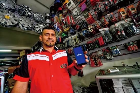 ▲萨尔瓦多首都圣萨尔瓦多，一家商店的员工展示“Chivo钱包”应用程序 图/视觉中国