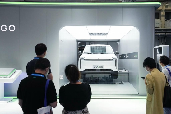 8月26日，2022世界新能源汽车大会上，参观者在观看一辆可换电池新能源汽车的换电演示。新华社记者 鞠焕宗 摄
