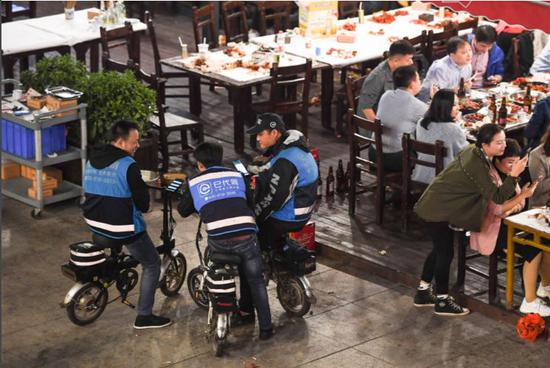 今年年10月12日,在长沙渔人船埠的夜市旁,代驾司机在守候订单 薛宇舸/摄