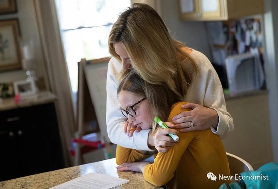 当地时间2020年3月18日，美国新罗谢歇尔，法拉·伊顿在辅导11岁的女儿艾琳学习