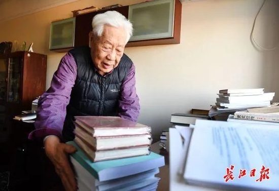 中南财经政法大学退休教授赵德馨在家中书房办公，清理案头书籍和资料。记者高勇 摄