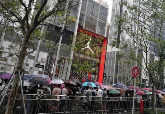 图解：深圳万象天地AJ旗舰店开业第一天，几百人冒雨排队，摇号抢限量款。