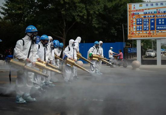6月16日，北京蓝天救援队队员在岳各庄批发市场开展消杀作业。图片来源：新华社 陈钟昊 摄