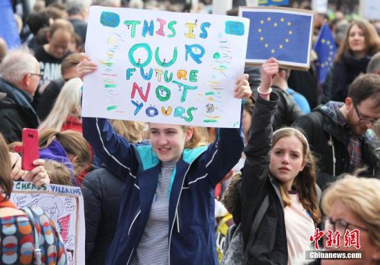 3月23日，在欧盟同意英国延迟脱欧、英国脱欧前景仍面临“灾难的不确定性”困境之际，伦敦市中心举行了大规模呼吁举行“第二次脱欧公投”的示威游行。名为“交给人民”的组织者声称，参加示威游行的英国民众来自全国各地，超过一百万人。图为高举标语的少女。中新社记者 张平 摄
