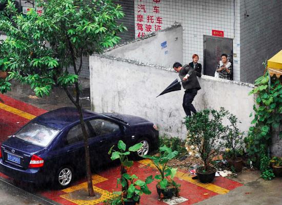  （2009年11月12日，广东佛山教子村封村查暂住证，一名打工者跳墙逃跑。图/视觉中国）