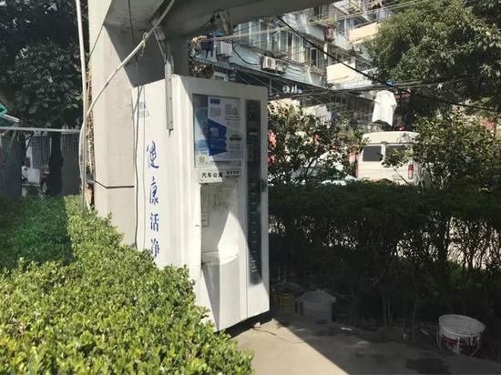 杨浦区江浦汽车公寓小区内的一台自动售水机，大风吹开了取水窗口。
