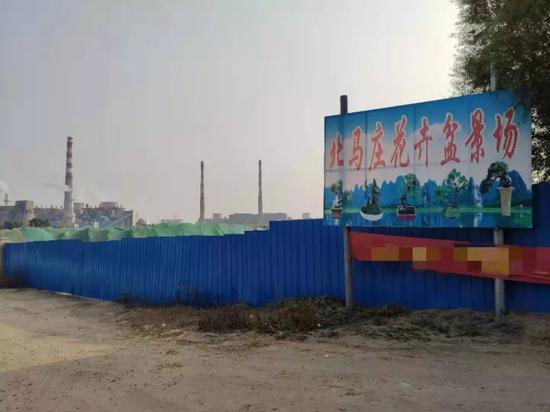土地四周围上了蓝色彩钢板，广告牌上说这里是“北马庄花卉盆景场”。