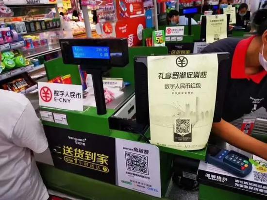 ↑图为在深圳华润万家罗湖区春风店，人工收银台有标识提示顾客可使用数字人民币。