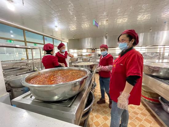 库车石榴籽服饰公司食堂在等待开饭，午餐是拉条子（范凌志摄）
