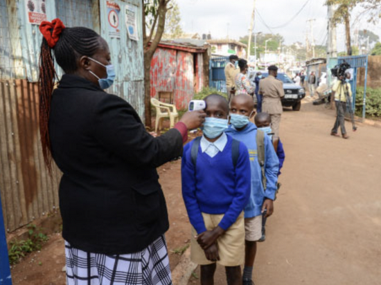 ■ 在肯尼亚内罗毕，老师在课程开始前为学生测量体温 / 盖蒂图片社 （SOPA）