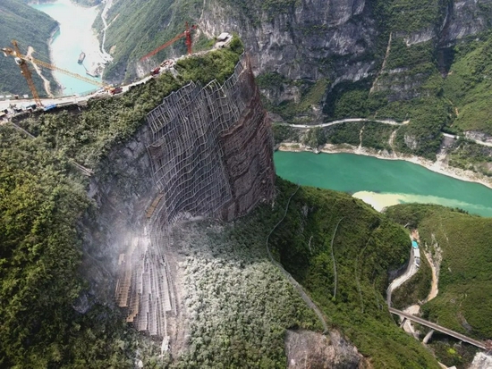 或山石滚落防止雨水他们在为危岩体增设防护设施悬挂在仰坡峭壁上施工
