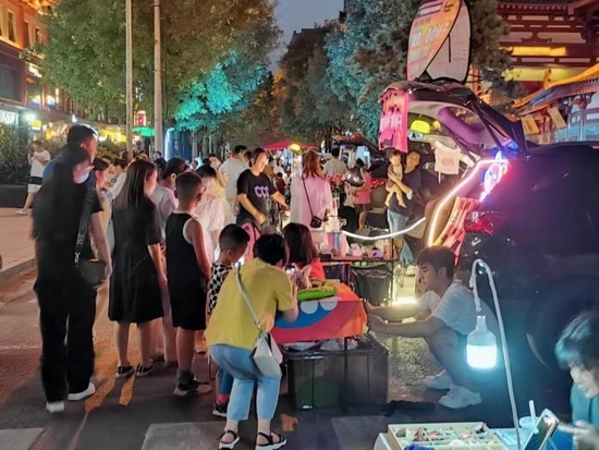 在后备箱摊主前购买商品的顾客