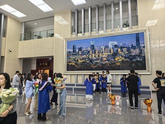 北京某高校内,硕士研究生拍摄毕业照。