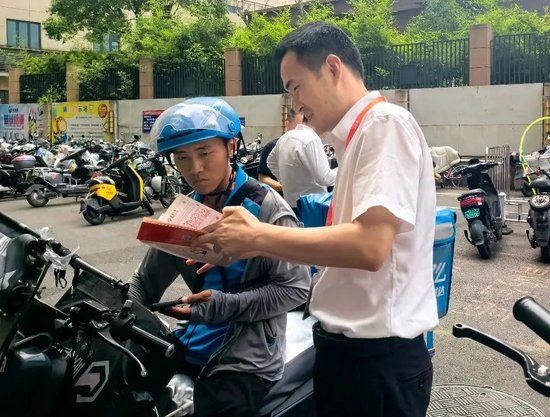 泰康人寿福建分公司的“消保志愿者”在为快递小哥义务解答