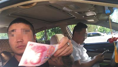 号贩子隔着车窗给一名兼职人员100元作为报酬。