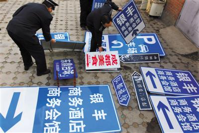 2009年12月8日，北京相关部门在整治行动中，拆除“山寨指路牌”。图/视觉中国