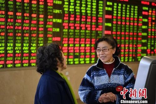 1月11日，股民在四川成都某证券交易大厅内讨论交流。（资料图）中新社记者 刘忠俊 摄