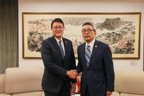 △蔡伟（右）会见加勒比国家驻华使团团长、牙买加驻华大使丘伟基