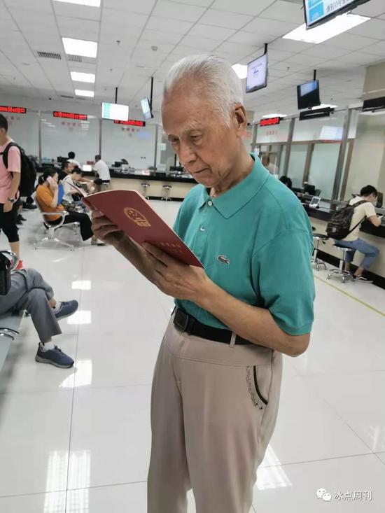 张光兴在北京市丰台区不动产登记中心领回房产证。受访者供图
