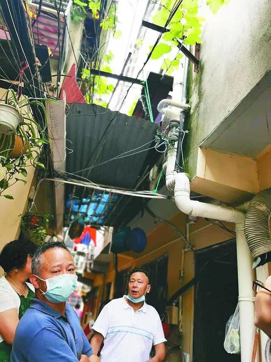 7月16日,上海宝昌路棚户区居民向记者介绍电马桶的管道设计。中青报·中青网记者王烨捷/摄