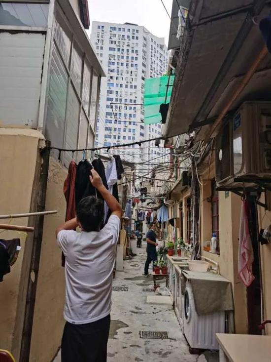 宝昌路棚户区居民出门晾衣服。他们在两栋房子间拉一条绳子,解决晾晒需求。中青报·中青网记者王烨捷/摄