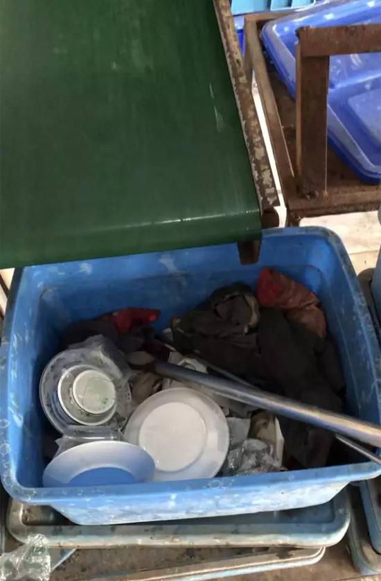 ▲传送带下的箱子里散落着来不及装箱的餐具,里面的脏抹布用来擦抹塑料箱。新京报记者 刘经宇 摄