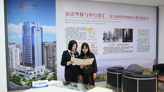 ▲福清分行营业部工作人员向客户介绍外汇业务