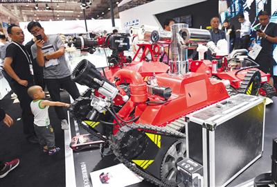 8月21日，世界机器人大会展厅，人们在观看小型智能消防灭火机器人。本版摄影/新京报记者 吴宁