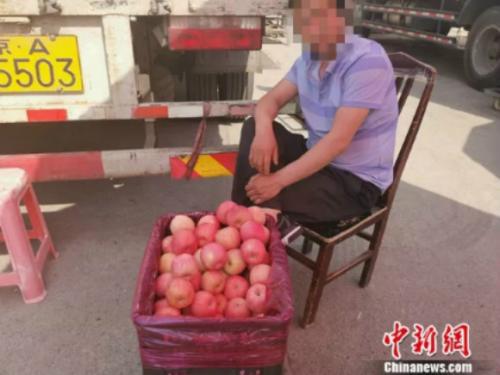 图为新发地卖苹果的摊贩。 谢艺观 摄
