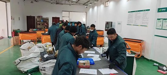  ▲西藏拉萨城东营业部分拣员正在传送带分拣。旦增 | 摄